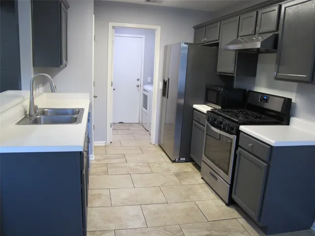 a kitchen with a sink a stove and refrigerator