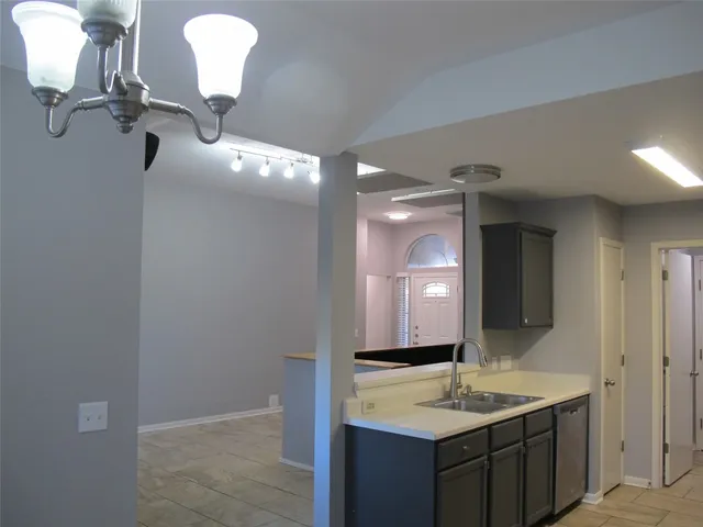 a bathroom with a granite countertop sink a light fixture and a mirror