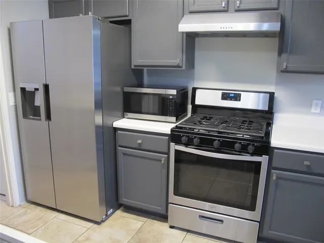 a stove top oven sitting inside of a kitchen