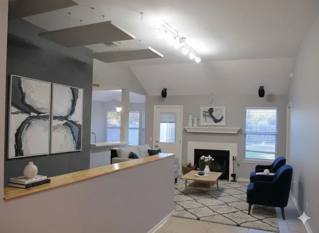 a living room with furniture a fireplace and a large mirror