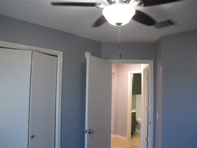 a view of a hallway with a chandelier fan and wooden floor