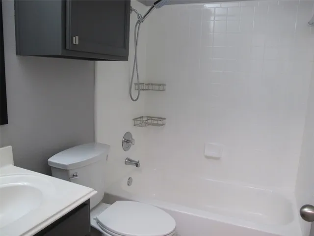 a white toilet sitting next to a bath tub