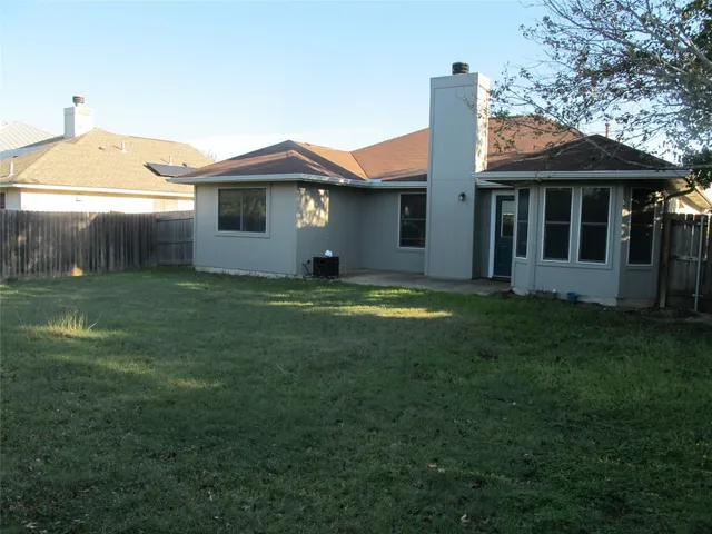 a view of a yard in front of a house with large trees