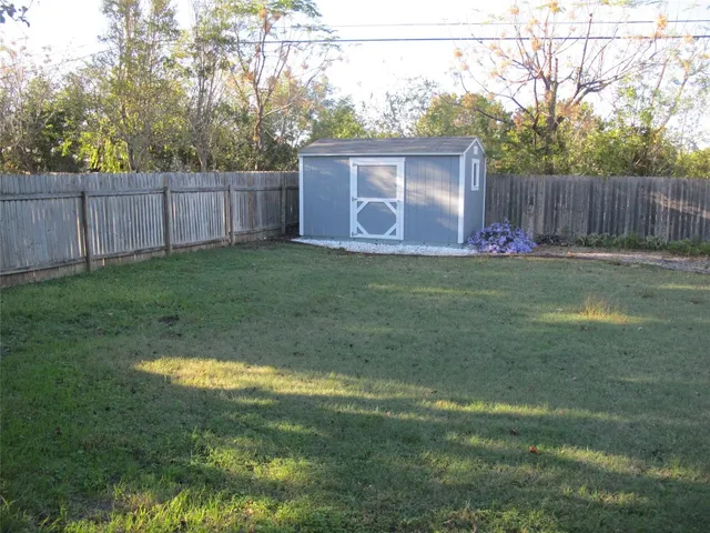 a view of a backyard with table and chairs and wooden fence