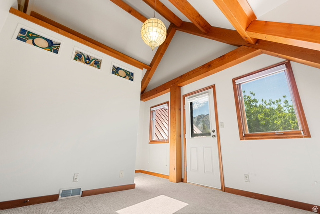 435 Canyon Road Millville, UT 84326 - Photo 29 of 113 Vaulted ceiling with exposed wood beams, stained glass transom windows, wood-trimmed windows, a ceiling-mounted light fixture, and carpet flooring