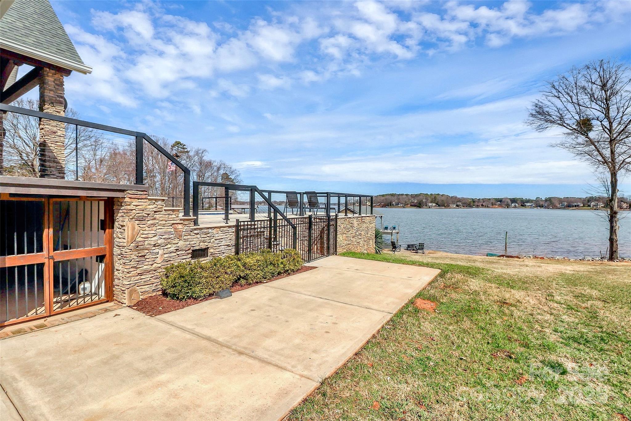 5086 Windward Point Lane Denver, NC 28037 - Photo 31 of 36 a view of roof deck with large trees and wooden fence
