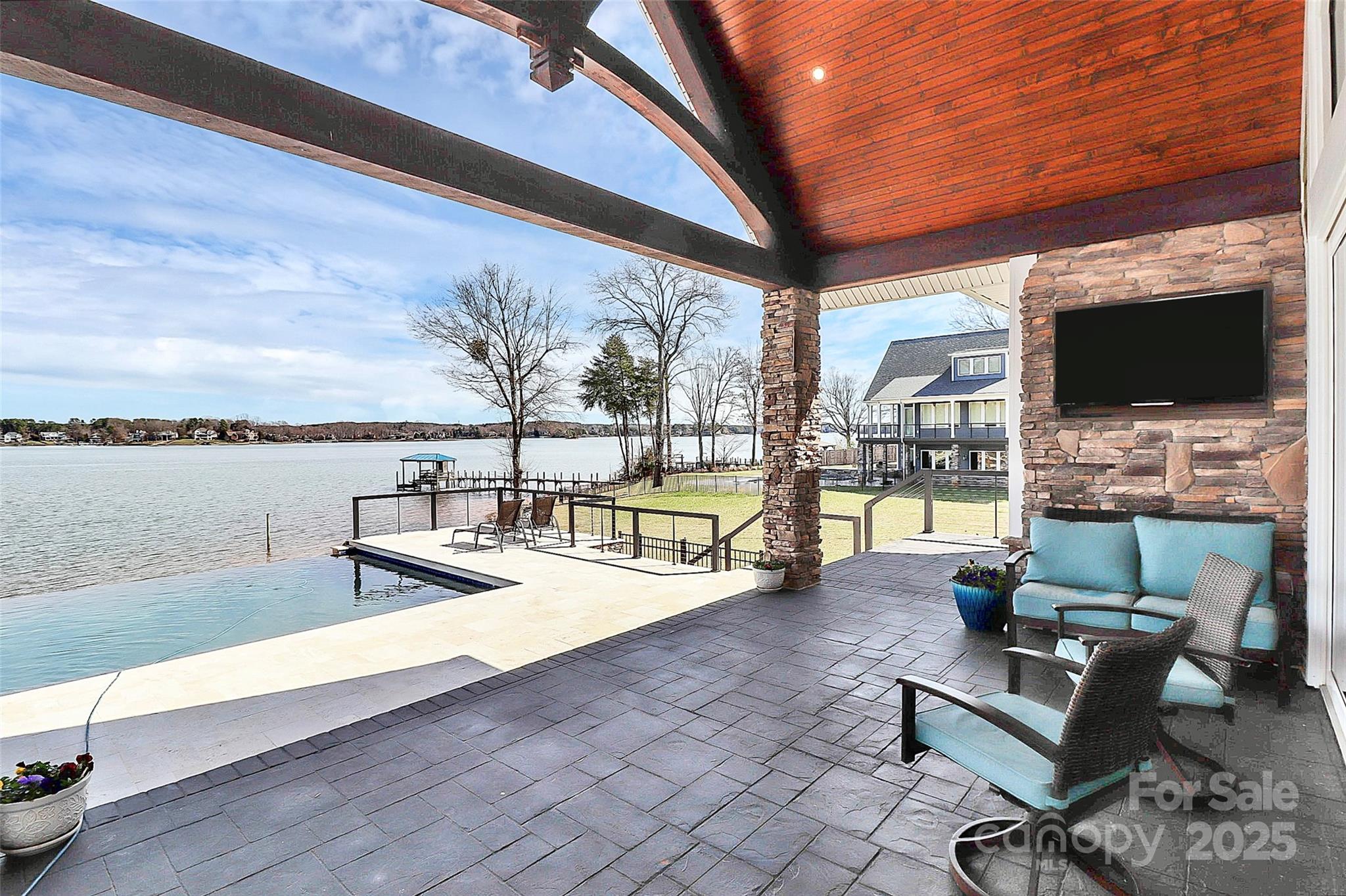 5086 Windward Point Lane Denver, NC 28037 - Photo 5 of 36 a living room with furniture a flat screen tv and a floor to ceiling window