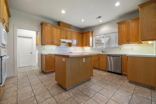 a kitchen with stainless steel appliances granite countertop a stove a sink and a refrigerator