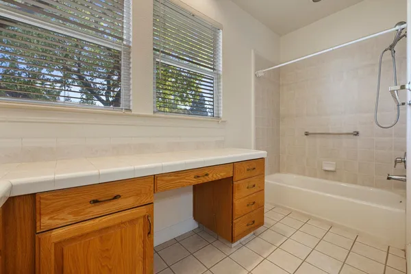 an empty room with windows and ceiling fan
