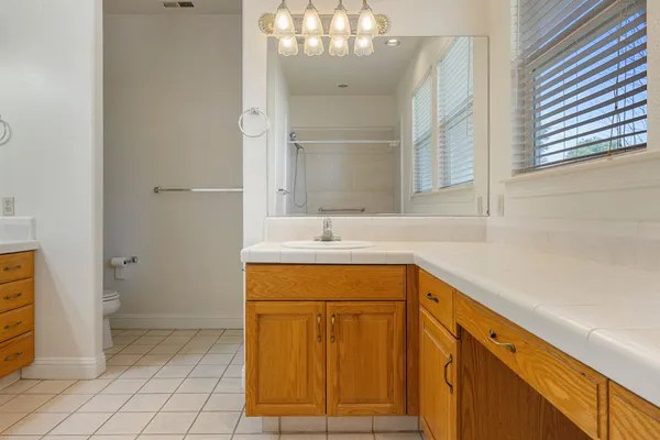 an empty room with chandelier fan and closet