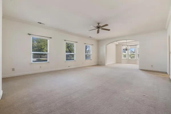 en empty room with windows and chandelier
