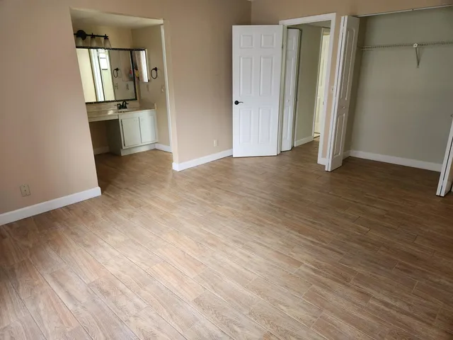 an empty room with wooden floor and entrance