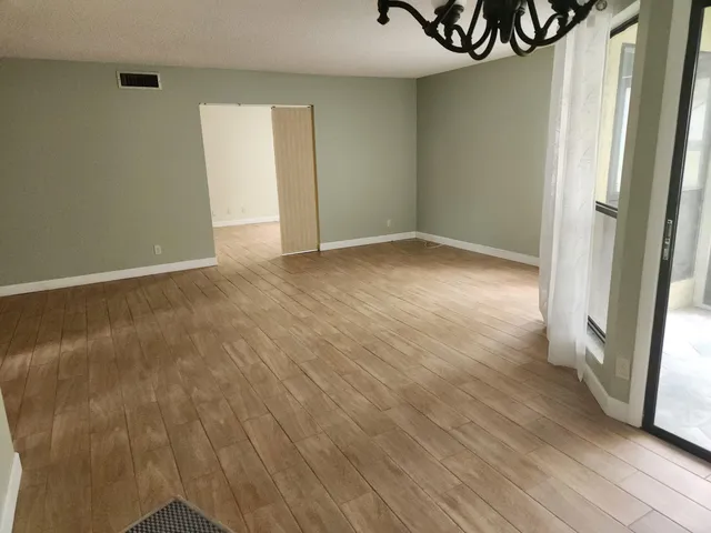 an empty room with wooden floor and a window