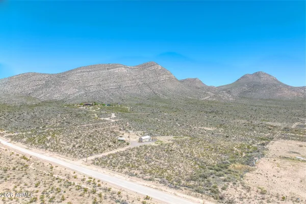 a view of a dry yard with mountains in the background