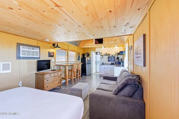 a living room with furniture a flat screen tv and a floor to ceiling window
