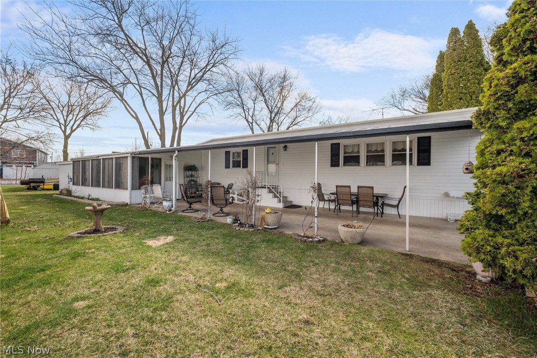 1623 Northeast Catawba Road, Unit 160 Port Clinton, OH 43452 - Photo 24 of 28 Side view featuring a three-season room, yard, and patio