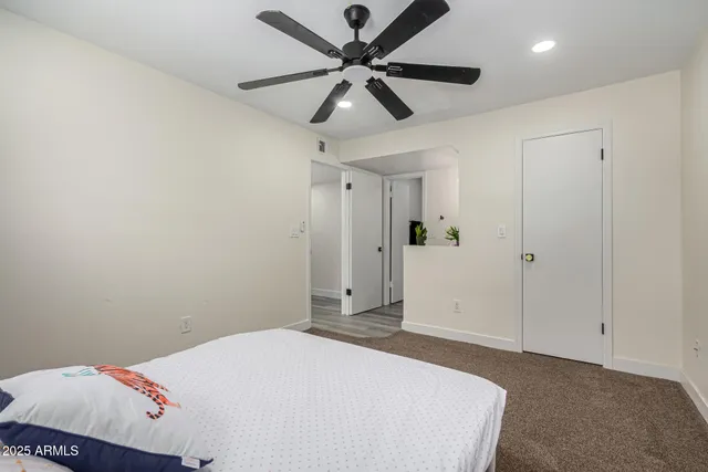 a bedroom with a bed and a ceiling fan