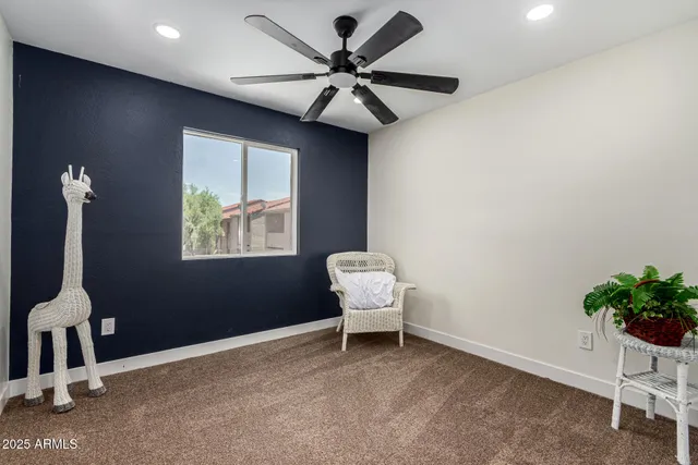 a room with a chair and a ceiling fan