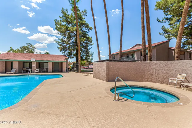 a blue swimming pool with outdoor seating and yard