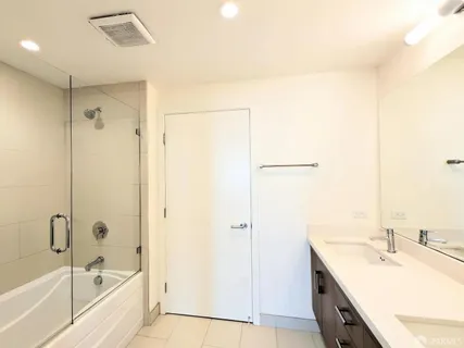 a bathroom with a bathtub shower sink vanity and a mirror