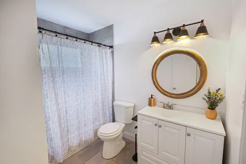 a bathroom with a toilet a sink and a mirror