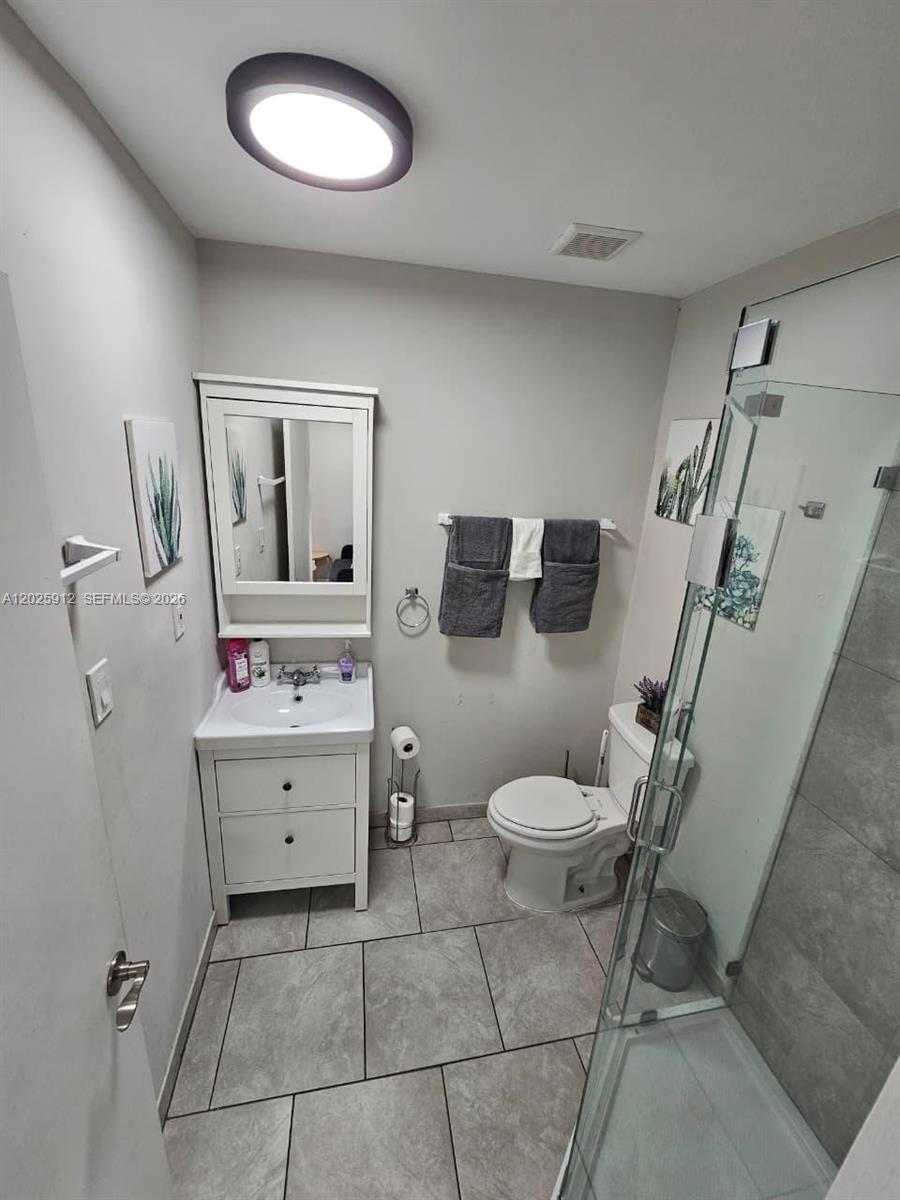 2224 Southwest 11th Street, Unit 3 Miami, FL 33135 - Photo 11 of 15 a bathroom with a toilet sink and mirror