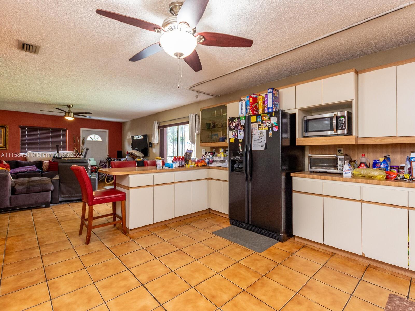 6731 Southwest 5th Terrace Miami, FL 33144 - Photo 16 of 33 a kitchen with stainless steel appliances kitchen island granite countertop a refrigerator and microwave