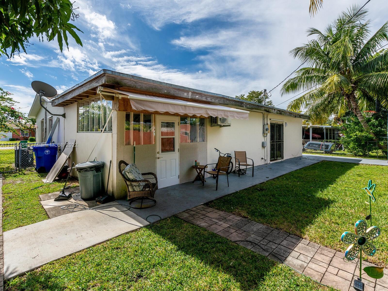 6731 Southwest 5th Terrace Miami, FL 33144 - Photo 29 of 33 a backyard of a house with table and chairs plants and large tree