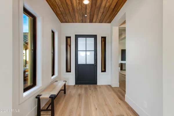 a hall way with wooden floor and furniture