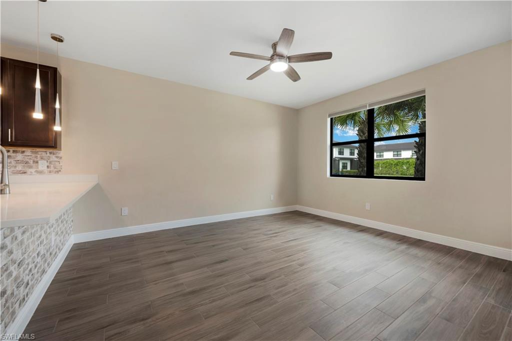 7549 Carnegie Way Naples, FL 34119 - Photo 4 of 22 a view of a livingroom with wooden floor a ceiling fan and windows