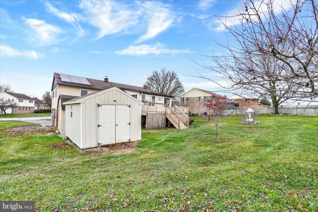 a view of a tiny house with a big yard and large tree