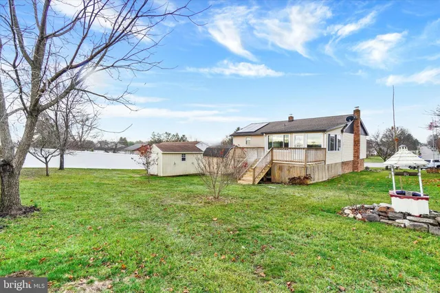 a view of a house with a big yard and large trees
