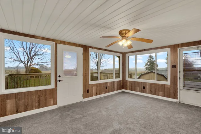 an empty room with windows and chandelier