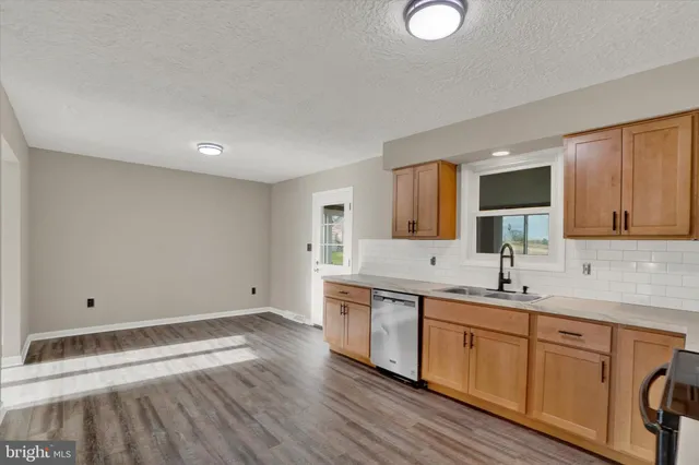 a kitchen with a sink cabinets and wooden floor