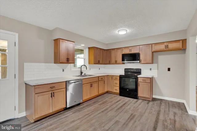 a kitchen with a sink cabinets stainless steel appliances and a window