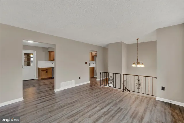 a view of a hallway with wooden floor and stairs