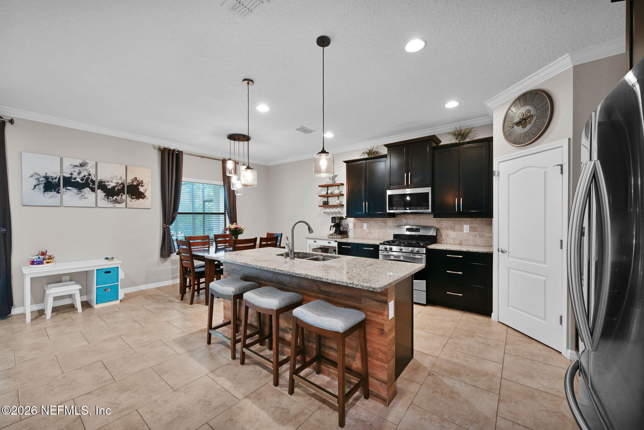 212 North Arabella Way St. Johns, FL 32259 - Photo 20 of 83 a kitchen with stainless steel appliances kitchen island granite countertop a table chairs microwave and sink