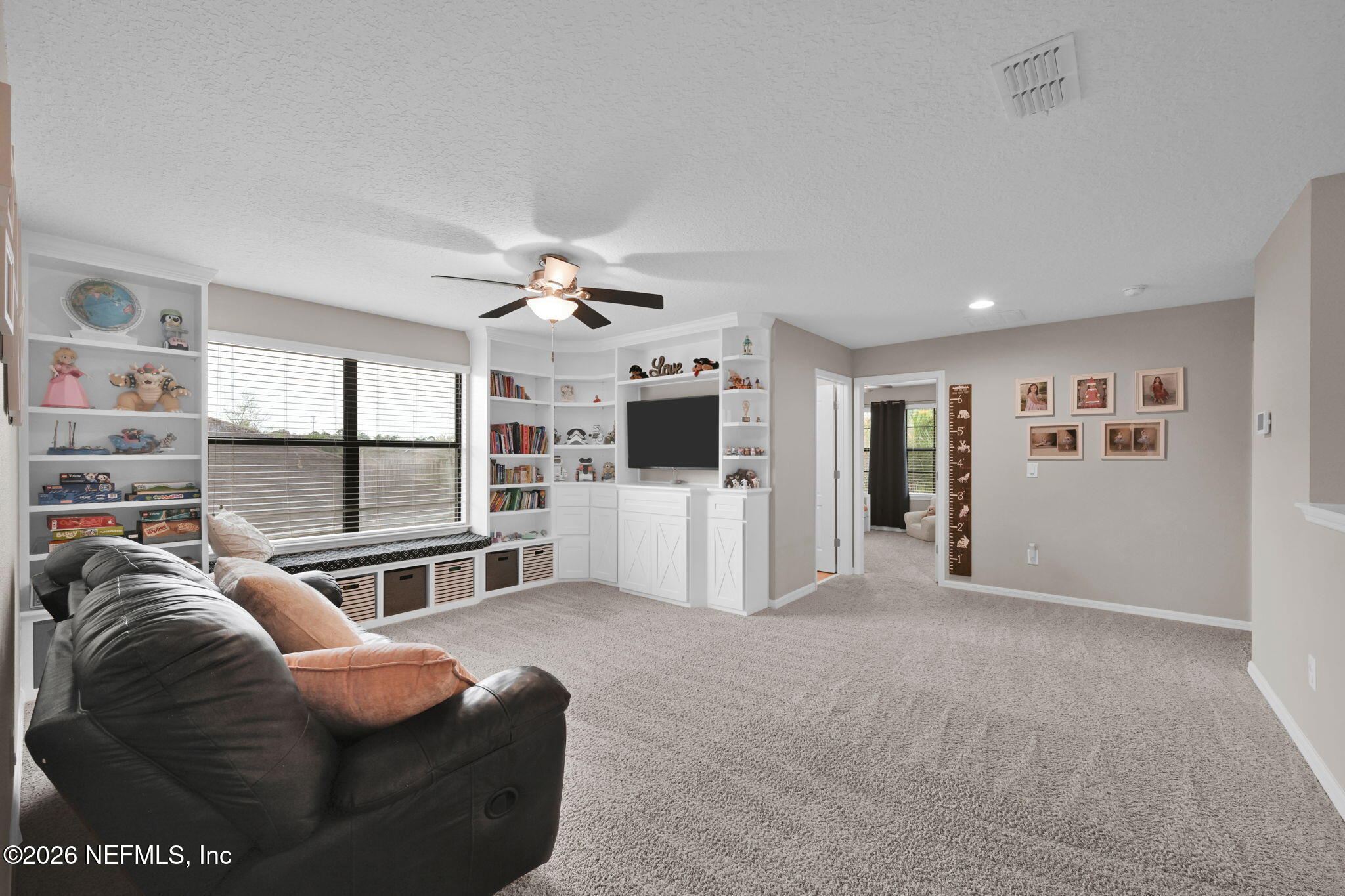 212 North Arabella Way St. Johns, FL 32259 - Photo 35 of 83 a living room with furniture a flat screen tv and a floor to ceiling window
