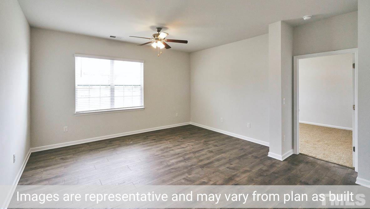 608 Rex Court Carthage, NC 28327 - Photo 17 of 22 an empty room with wooden floor chandelier and windows
