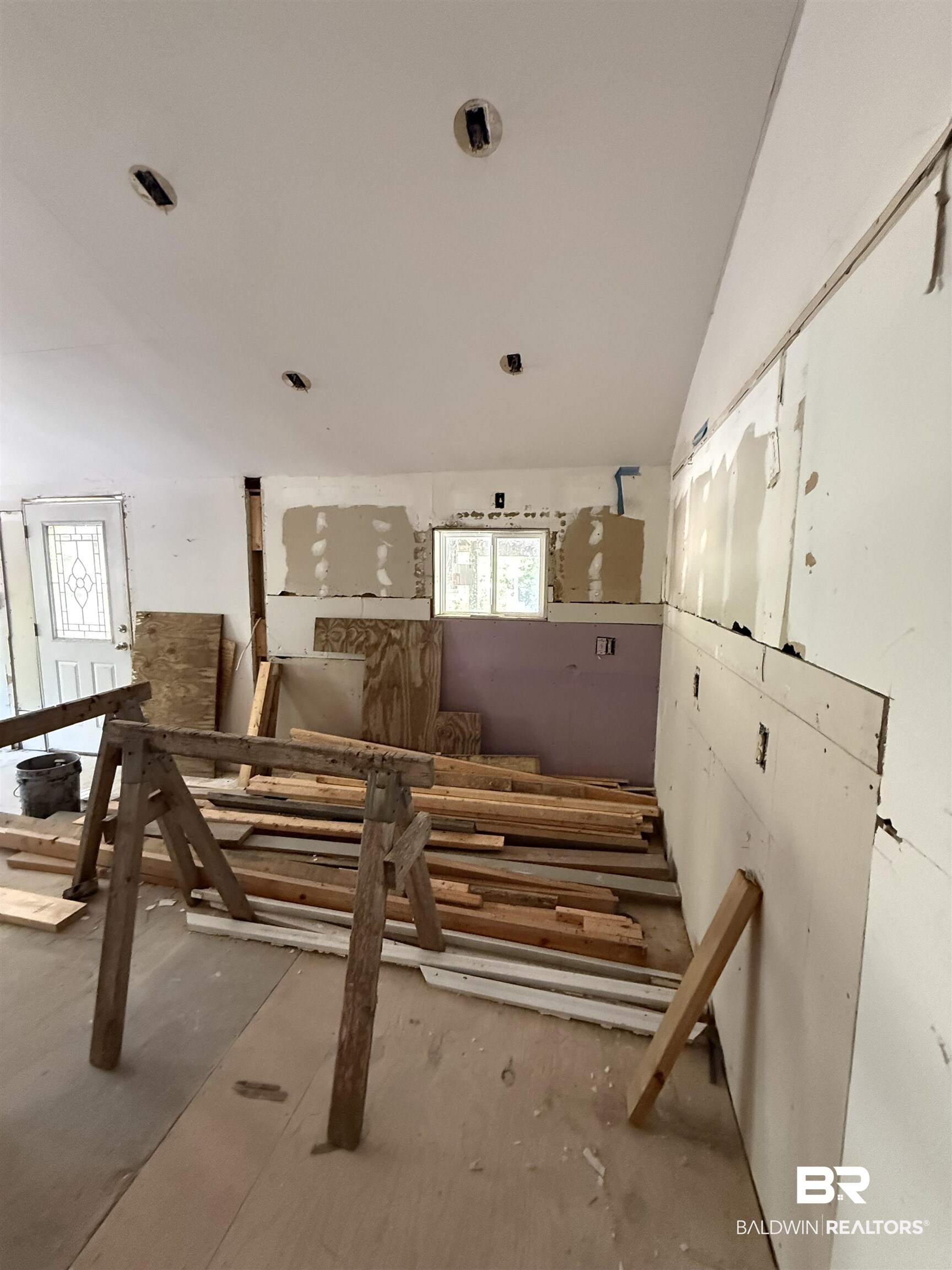 1276 Rio Circle Lillian, AL 36549 - Photo 3 of 7 Renovation-ready interior space featuring exposed wall framing, partially installed drywall, and a window opening