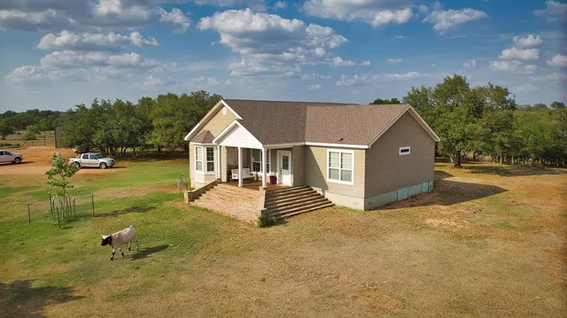 a backyard of a house with table and chairs