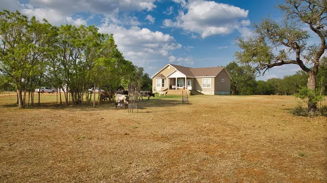 a view of a patio with couches and table and chairs under an umbrella