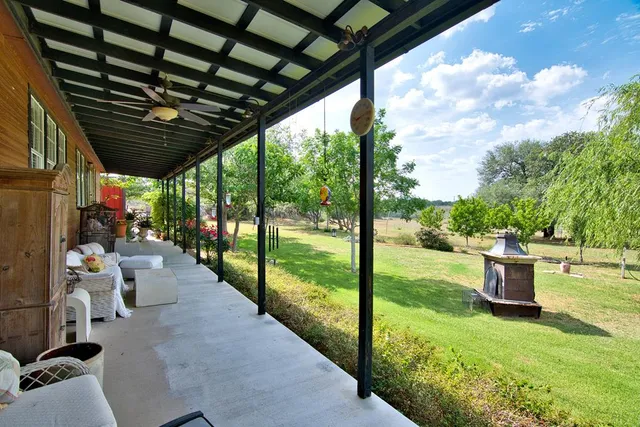 a view of a dining room with furniture a chandelier and large windows