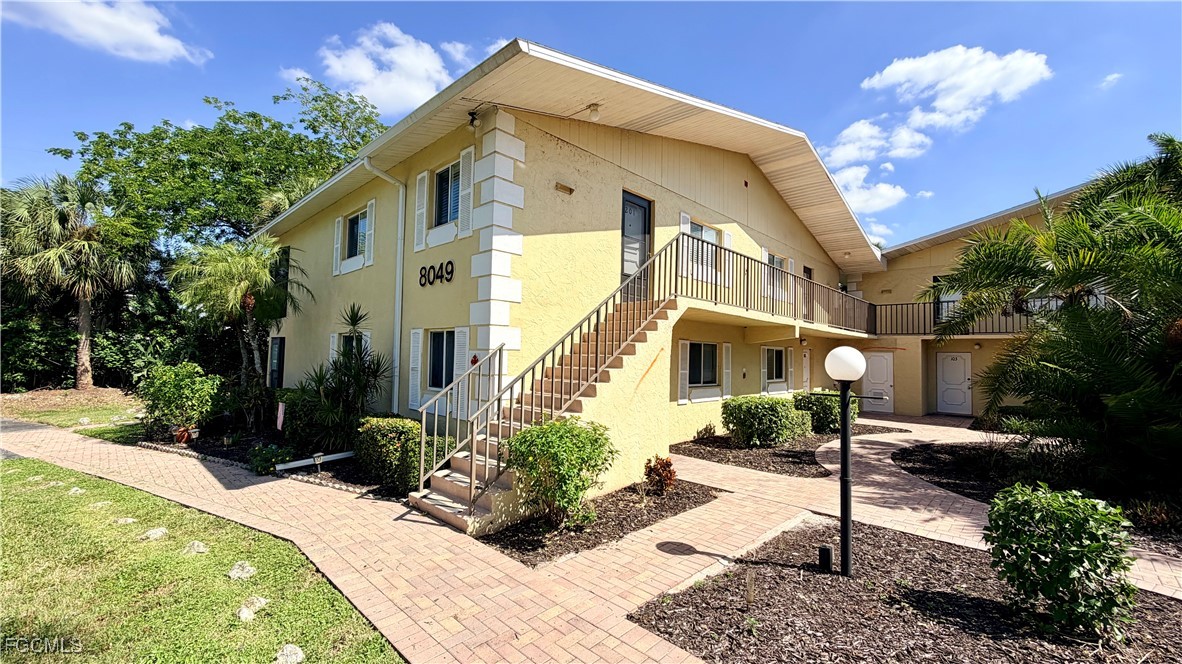 8049 Country Road, Unit 101 Fort Myers, FL 33919 - Photo 1 of 19 a front view of a house with a yard