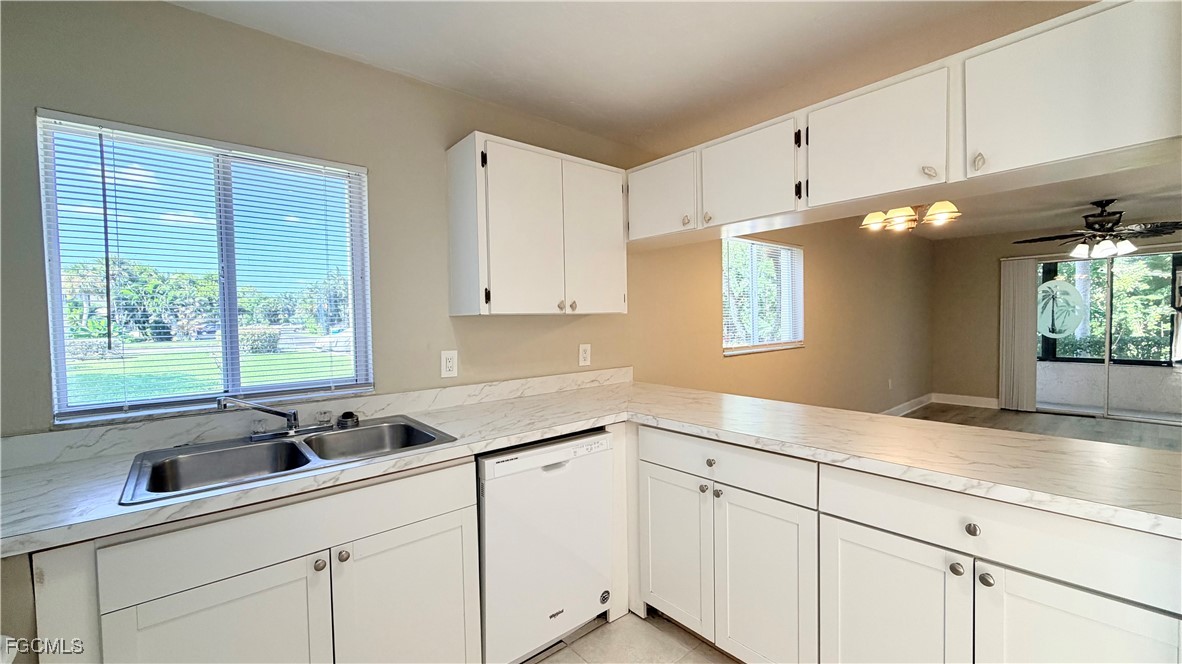 8049 Country Road, Unit 101 Fort Myers, FL 33919 - Photo 8 of 19 a kitchen with granite countertop a sink white cabinets and a large window