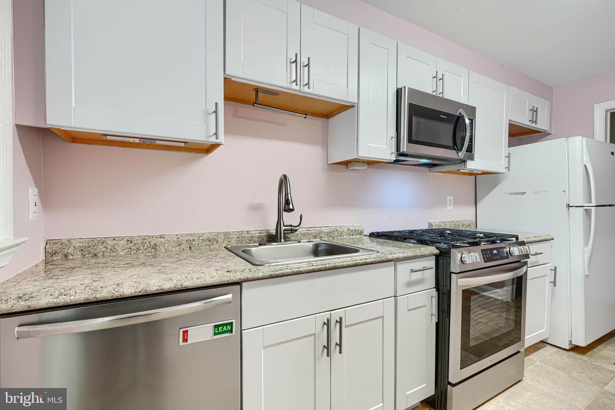 7807 Rockbourne Road Dundalk, MD 21222 - Photo 12 of 31 a kitchen with stainless steel appliances granite countertop a sink stove and microwave
