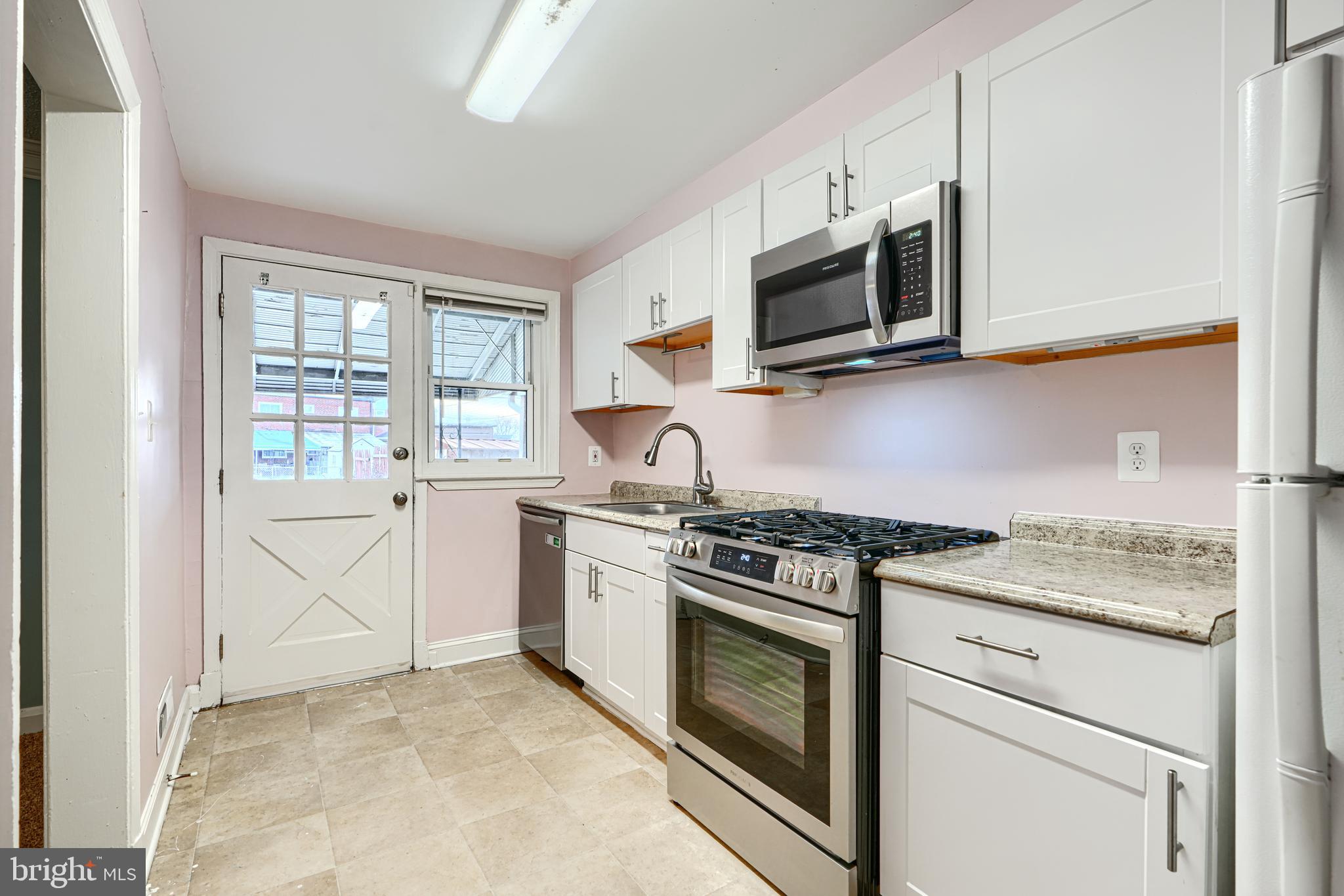 7807 Rockbourne Road Dundalk, MD 21222 - Photo 13 of 31 a kitchen with stainless steel appliances granite countertop white cabinets and a stove top oven