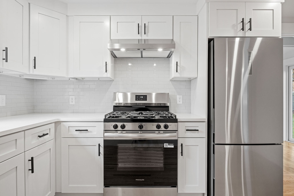 18 Martin Street Wareham, MA 02532 - Photo 17 of 42 a kitchen with refrigerator a stove and white cabinets