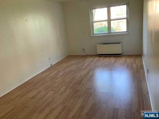1111 River Road, Unit F2 Edgewater, NJ 07020 - Photo 13 of 21 an empty room with wooden floor and windows