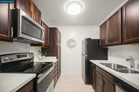 a kitchen with stainless steel appliances granite countertop a refrigerator stove and sink